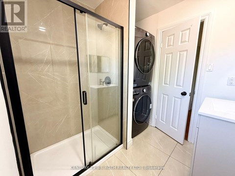 A bathroom with a glass shower door and a white door.