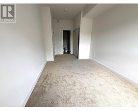 A spacious room with a carpeted floor and white walls.