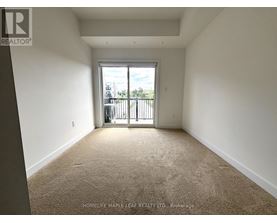 A room with a carpeted floor and a sliding glass door leading to a balcony.