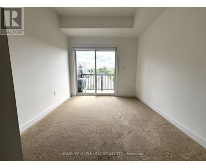 A room with a carpeted floor and a sliding glass door leading to a balcony.