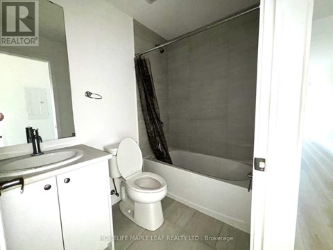 A bathroom with a toilet, sink, and shower.