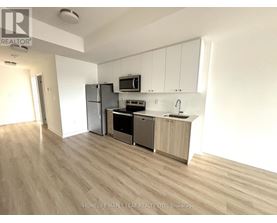 A kitchen with wooden floors and white walls.