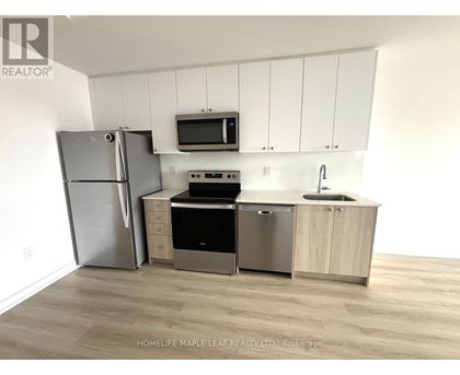 A kitchen with a refrigerator, microwave, oven, sink and cabinets.