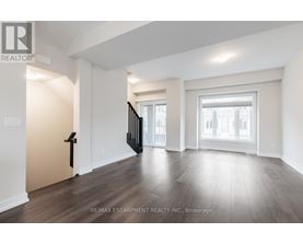 A spacious room with wooden floors and white walls.