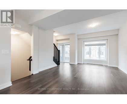 A spacious room with wooden floors and white walls.
