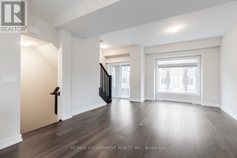 A spacious room with wooden floors and white walls.