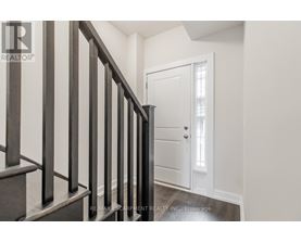 A hallway with a white door and a wooden staircase.