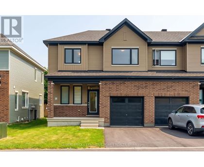 A house with a grey car parked in front.