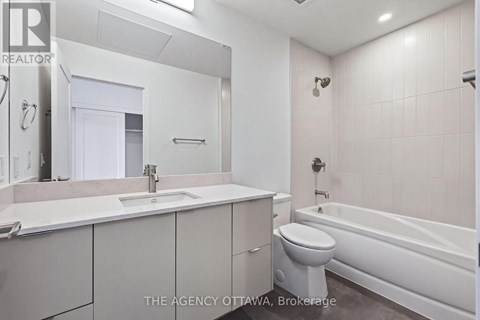 A white bathroom with a toilet, sink, and bathtub.