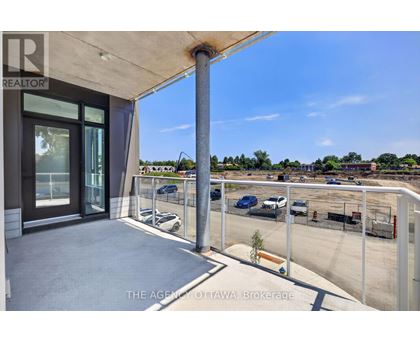 A balcony with a view of a parking lot and buildings.