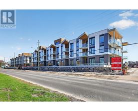 A row of multi-story residential buildings under construction with a red sign in front.