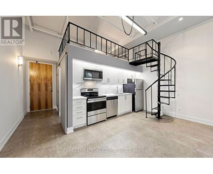 A spacious kitchen with a staircase leading to the upper level.