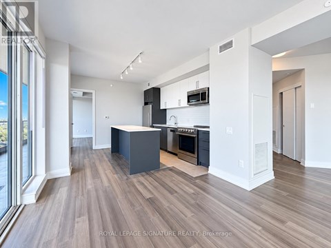 A modern kitchen with dark wood floors and white walls.