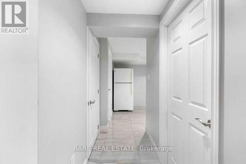 A hallway with white walls and a white door.
