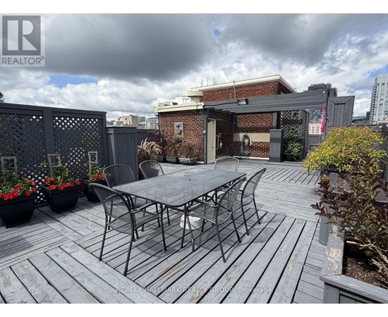 A patio with a table and chairs is set up on a wooden deck.
