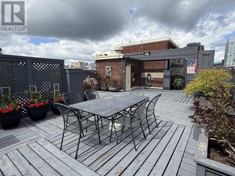 A patio with a table and chairs is set up on a wooden deck.