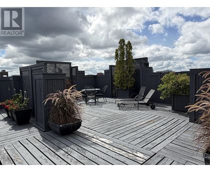 A wooden deck with a table and chairs surrounded by a fence.