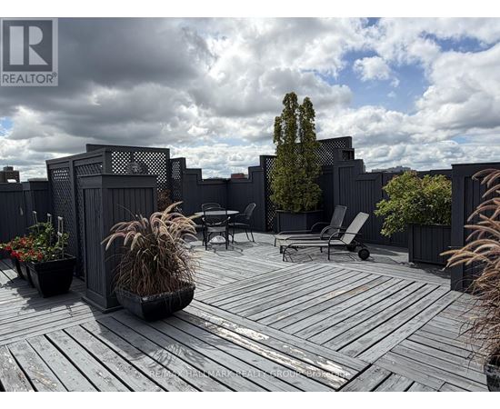 A wooden deck with a table and chairs surrounded by a fence.