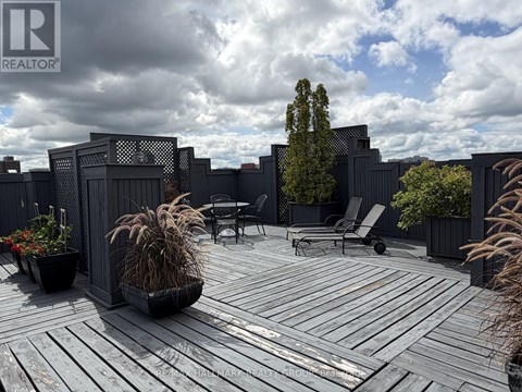 A wooden deck with a table and chairs surrounded by a fence.