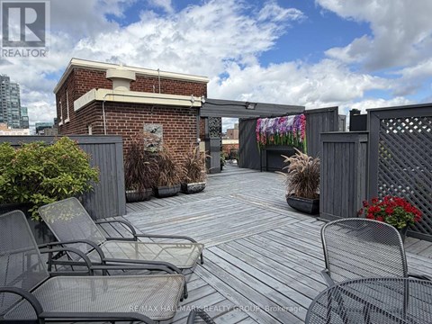 A patio with chairs and a table is surrounded by a brick wall.