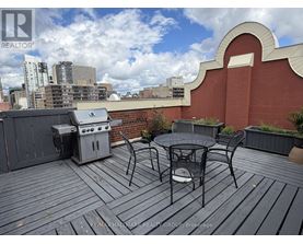 A balcony with a table and chairs overlooking a city skyline.