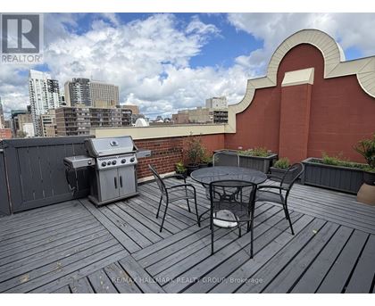 A balcony with a table and chairs overlooking a city skyline.