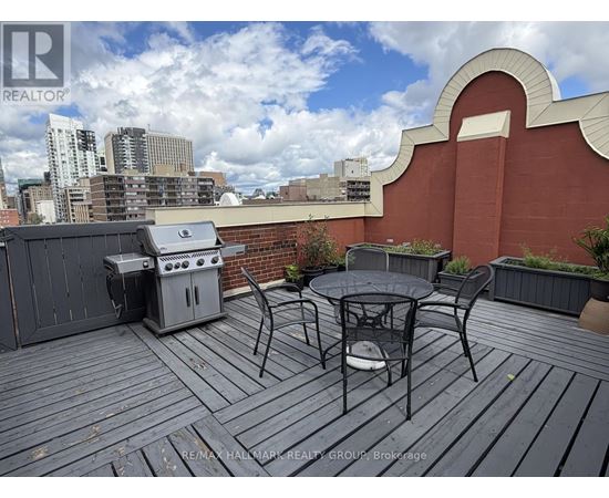 A balcony with a table and chairs overlooking a city skyline.