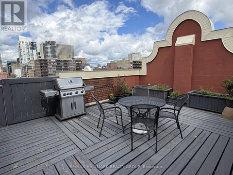 A balcony with a table and chairs overlooking a city skyline.