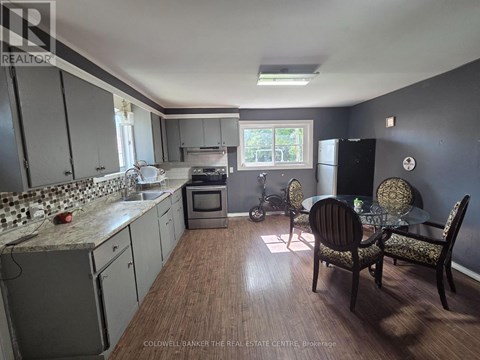 A kitchen with a dining table and chairs.