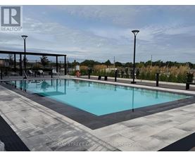 A large outdoor pool surrounded by a black railing.