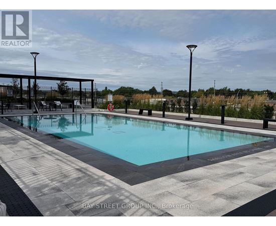 A large outdoor pool surrounded by a black railing.