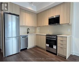 A kitchen with a refrigerator, oven, and microwave.