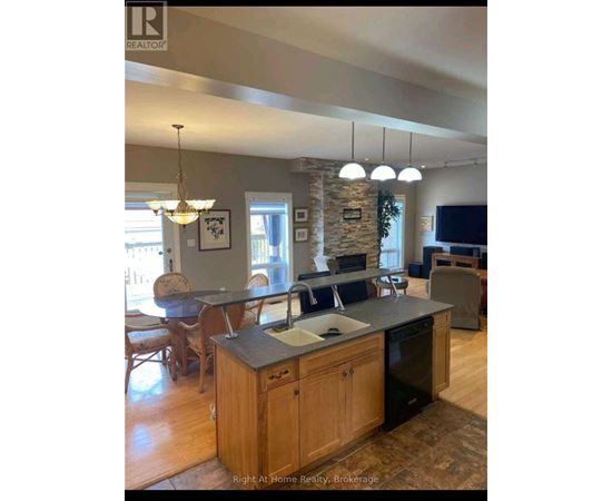 A kitchen with a stone pillar and a countertop with a sink.