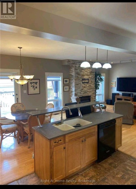 A kitchen with a stone pillar and a countertop with a sink.