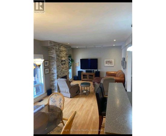 A living room with a stone pillar and a flat screen TV.