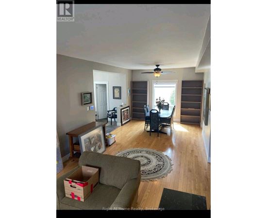 A living room with a grey couch and a rug.
