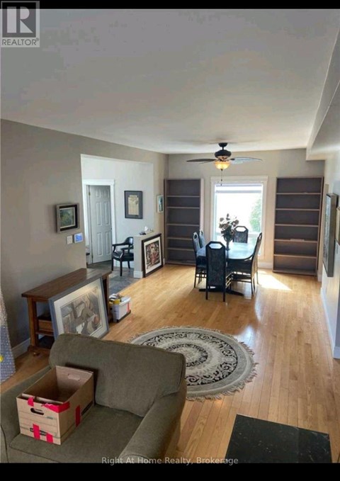 A living room with a grey couch and a rug.