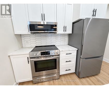 A modern kitchen with white cabinets and stainless steel appliances.