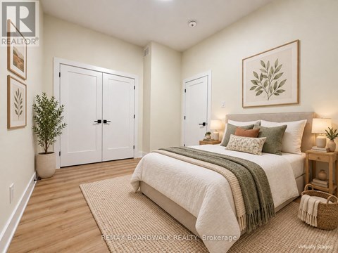 A bedroom with a large bed and a potted plant.