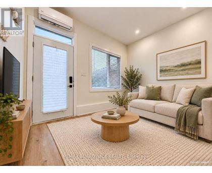 A living room with a couch, a coffee table, and a painting on the wall.