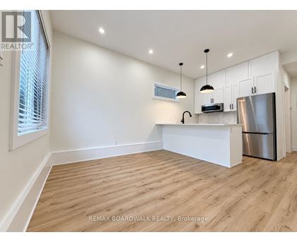 A kitchen with white cabinets and a wooden floor.