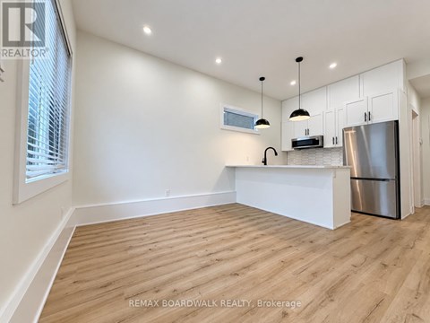 A kitchen with white cabinets and a wooden floor.