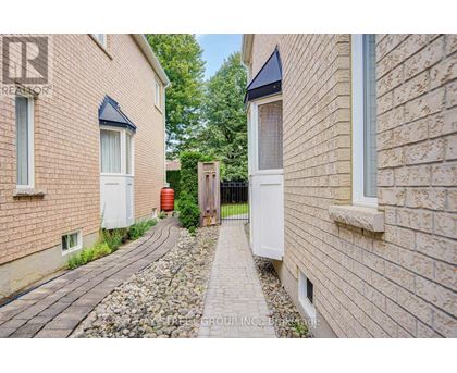 A narrow pathway between two brick buildings with a white door on the right.