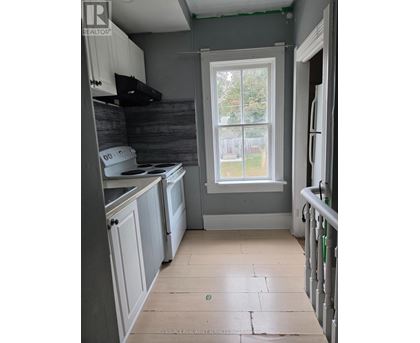 A kitchen with a window and a washing machine.