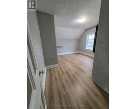 A room with wooden flooring and a window.