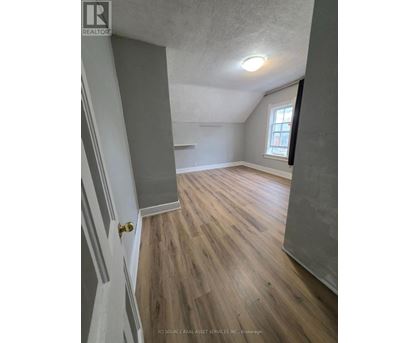 A room with wooden flooring and a window.