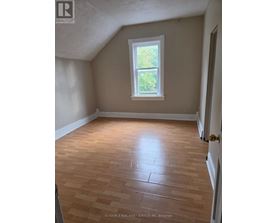 A room with a window and wooden flooring.