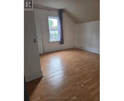 A room with a window and wooden flooring.