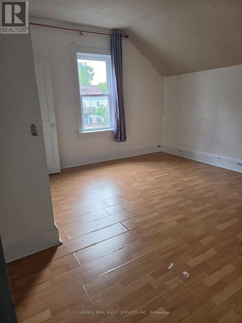 A room with a window and wooden flooring.