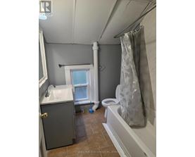 A bathroom with a toilet, sink, and shower.